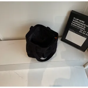 Black corduroy tote bag interior detail, large capacity shoulder handbag for women and students.