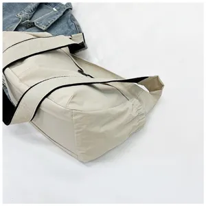 Close-up detail of casual nylon shoulder messenger bag with black strap and side pocket design.