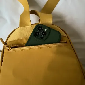 Compact yellow nylon mini backpack featuring a convenient front zipper pocket and top handles.