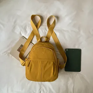Detail shot of a small yellow nylon casual backpack featuring simple design and daily use.