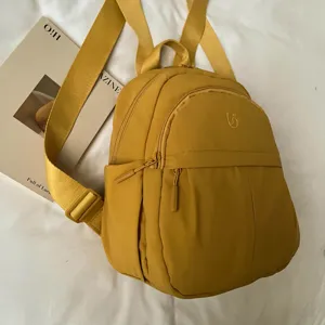 Casual yellow nylon small backpack for women, stylish and minimalist daily commuter book bag.