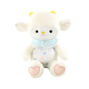 Mignonne peluche agneau avec cornes jaunes, col bleu et barboteuse à carreaux, jouet doux.