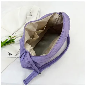 Detail view of the purple quilted puffer shoulder bag showing spacious interior and lining.
