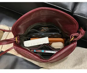 Interior detail of red leather envelope shoulder bag, large capacity with multiple compartments.