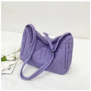 Close-up view of the purple quilted nylon shoulder bag detail, highlighting soft padding and stitching.