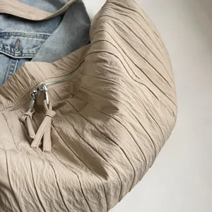 Dettaglio borsa a spalla plissettata casual, borsa a tracolla morbida minimalista in tessuto.