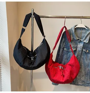Vista dettagliata della borsa a tracolla plissettata in nylon, accessorio casual elegante.