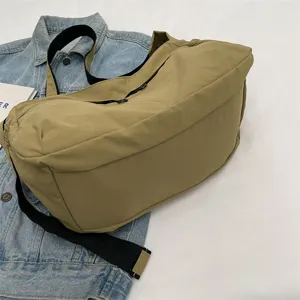 Vista dettagliata della borsa a tracolla casual in nylon cachi con ampia tracolla nera.