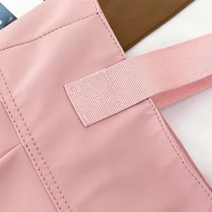 Pink nylon tote bag detail view, large capacity shoulder handbag for women daily commuting style.