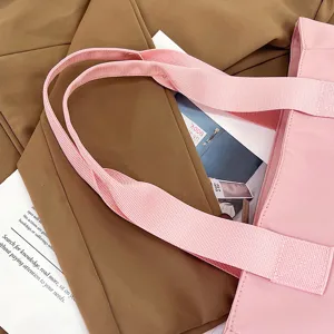 Close-up detail of a pink nylon tote bag shoulder strap, stylish daily accessory item.