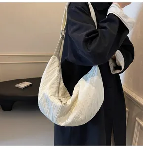 Vista dettagliata di una elegante borsa a tracolla plissettata bianca, in morbido tessuto.