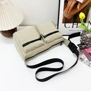 Casual beige multi-pocket nylon crossbody bag with black strap and zippers for daily commute.