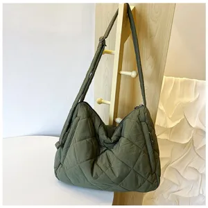 Detailed view of olive green quilted puffer shoulder bag, nylon material with soft texture.
