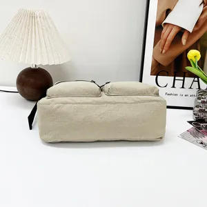 Close-up detail of beige casual canvas cross-body shoulder bag with double front pockets.