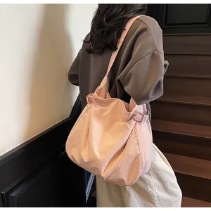 Casual pink nylon shoulder bag, lightweight slouchy tote with side buckles, commuter style.