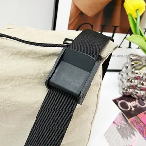 Detailed view of casual canvas crossbody bag strap and black plastic buckle daily use.