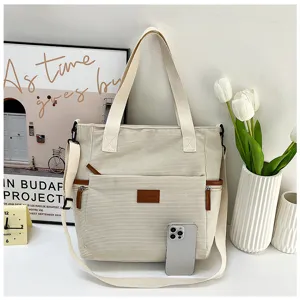 Large capacity corduroy tote bag detail showing front pocket and sturdy shoulder straps.