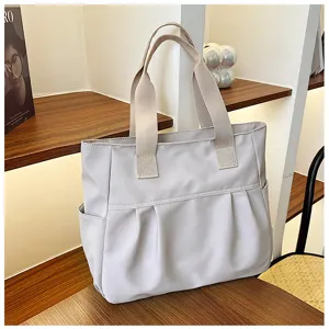 Light grey nylon tote bag, casual shoulder bag with dual handles and front pocket detail.
