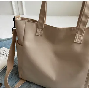 Detail view of waterproof nylon tote bag showing texture, straps, and stitching.