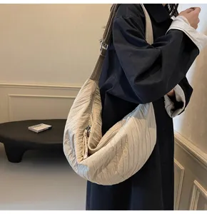 Dettagli della borsa a tracolla plissettata beige, texture morbida e grande capacità.