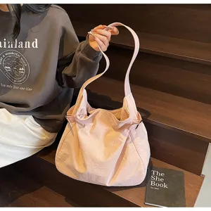 Casual pink nylon shoulder bag for women, lightweight hobo tote with adjustable side straps.