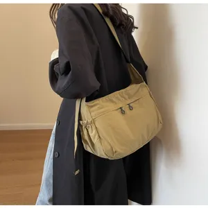 Primo piano della borsa a tracolla in nylon casual con tasca laterale e comoda cerniera.