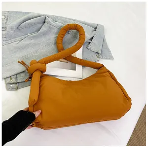 Detailed shot of the caramel padded knotted shoulder bag showing soft quilted texture and handle.