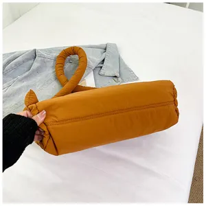 Close-up of the stylish padded knot handle and cylindrical design on this cozy handbag.