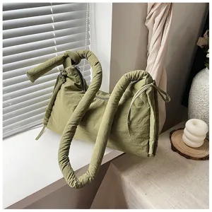 Olive green quilted shoulder bag detail, soft padded tote design with stylish knot handle.