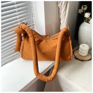 Detailed view of the soft padded shoulder bag featuring unique knot handle and spacious interior.