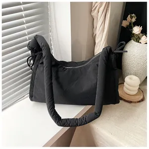 Detail view of the black quilted shoulder bag with knotted straps and zipper closure for daily commute.