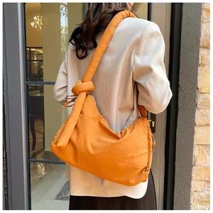 Padded shoulder crossbody bag with knotted strap and drawstring design for women.