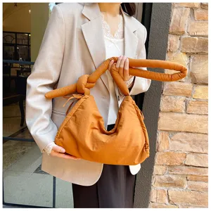 Brown quilted knotted shoulder bag detail, soft puffer tote handbag with drawstring design.