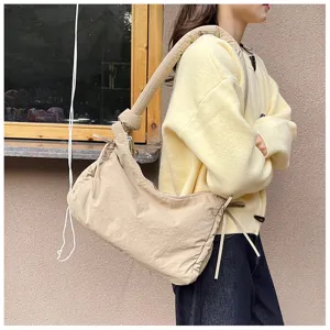 Quilted nylon shoulder bag with knot strap and drawstring details for women commuting.