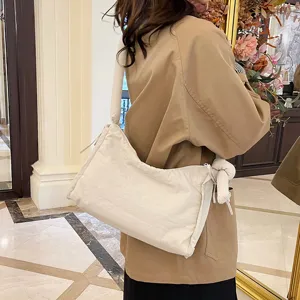 Solid color quilted shoulder bag with knot detail, soft large capacity crossbody handbag.