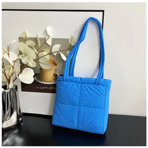 Blue nylon puffer tote bag for women, soft quilted shoulder bag and casual handbag.
