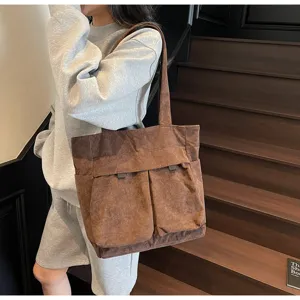 Detail view of brown corduroy tote bag, showcasing large capacity and front pocket design.