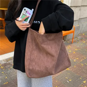 Brown suede tote bag detail, featuring large capacity and soft matte texture for daily wear.