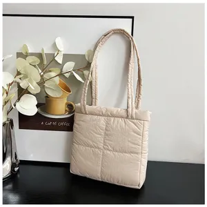 Detail view of a soft beige quilted nylon tote bag, showcasing fine stitching and texture.
