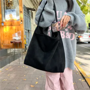 Detailed view of the black suede tote bag, showcasing large capacity and soft texture.