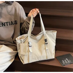 Detail shot of large capacity canvas tote bag with functional buckles and side pouch.