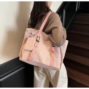 Detail view of the pink large-capacity shoulder tote bag, showcasing practical side strap and mini pouch.