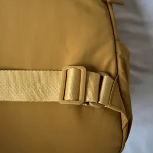 Close-up detail of a casual nylon backpack strap with adjustable plastic buckle for use.