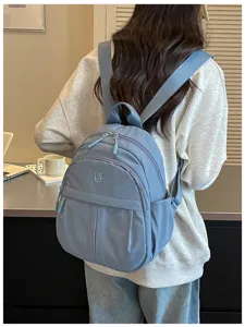 Detail view of the lightweight blue nylon casual backpack, featuring durable straps and zippers.