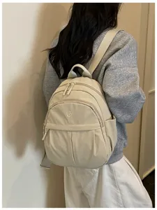 Nylon backpack detail, featuring multiple zip pockets and adjustable straps for daily casual commuting.