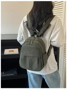Dark green nylon casual backpack detail view, lightweight everyday bag and commute use.