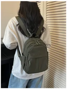 Casual nylon backpack detail featuring compact design, smooth zippers and side pockets.