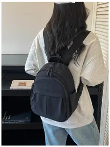 Back detail view of the lightweight black nylon mini backpack, simple and casual style.
