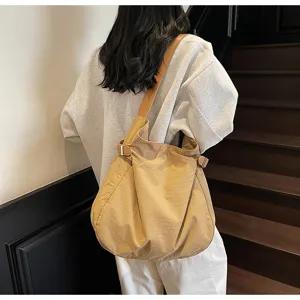 Detailed shot of the lightweight nylon shoulder bag, showing slouchy design and adjustable strap.