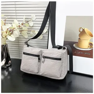 Casual grey nylon crossbody bag featuring double front zipper pockets and black strap details.